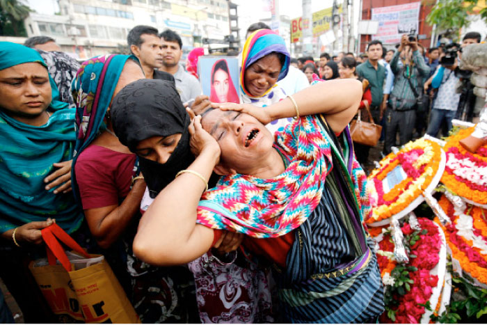 Relatives of victims killed in Rana Plaza building collapse in 2013, mourn at the site during the fourth anniversary of the collapse in Savar, on the outskirt of Dhaka, on Monday. — Reuters