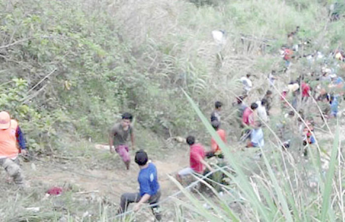 Volunteers try to rescue passengers after a bus they were traveling in apparently lost its brakes and plunged into a deep ravine in Carranglan township, Nueva Ecija province in northern Philippines, on Tuesday. — AP