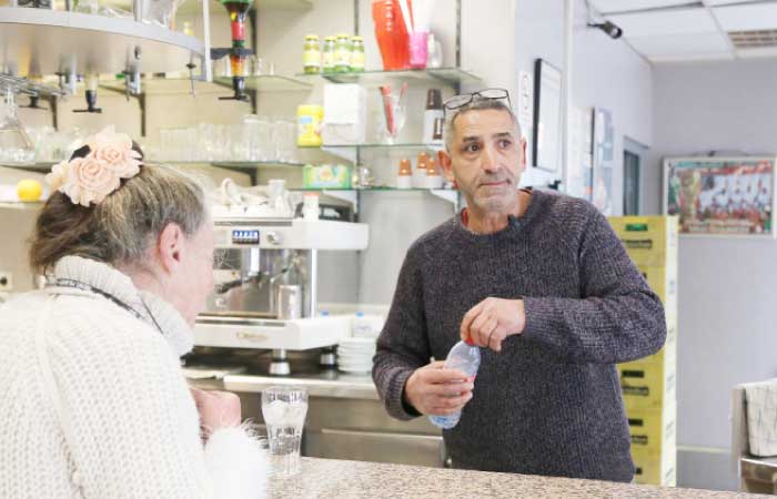 Amar Salhi is seen serving a customer at his cafe in Sevran, northeast of Paris. Salhi is still amazed at how his scruffy cafe north of Paris sparked an election scandal after it featured on national television in December during a report about Islam and women. — AFP