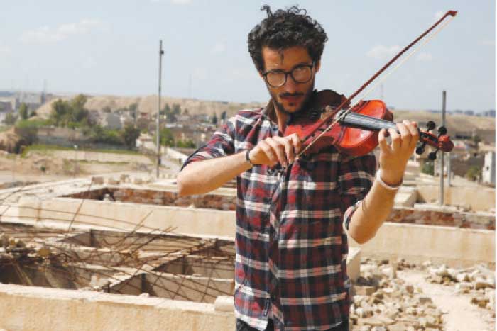 Ameen Mukdad, a violinist from Mosul who lived under Daesh rule for two and a half years where they destroyed his musical instruments, performs in eastern Mosul, Wednesday. — Reuters