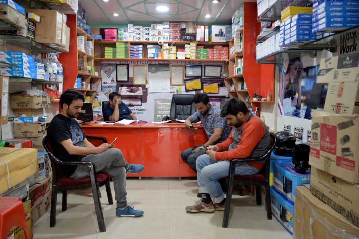 Kashmiri men looking at their mobile phones in a shop in Srinagar. An unprecedented ban on Whatsapp, Facebook and Twitter in the troubled Indian state has highlighted social media’s role in energizing an insurgency that has roiled the disputed Himalayan region for decades. — AFP