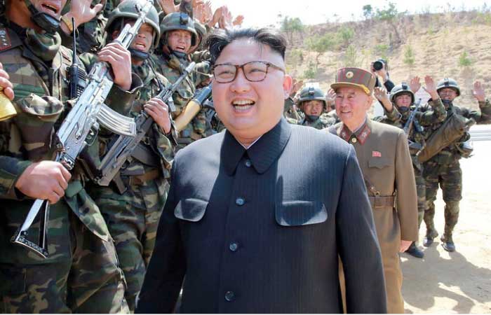 Korean People’s Army (KPA) soldiers walk before the portraits of late North Korean leaders Kim Il-Sung (left) and Kim Jong-Il (right) following the opening ceremony for the Ryomyong Street housing development in Pyongyang.