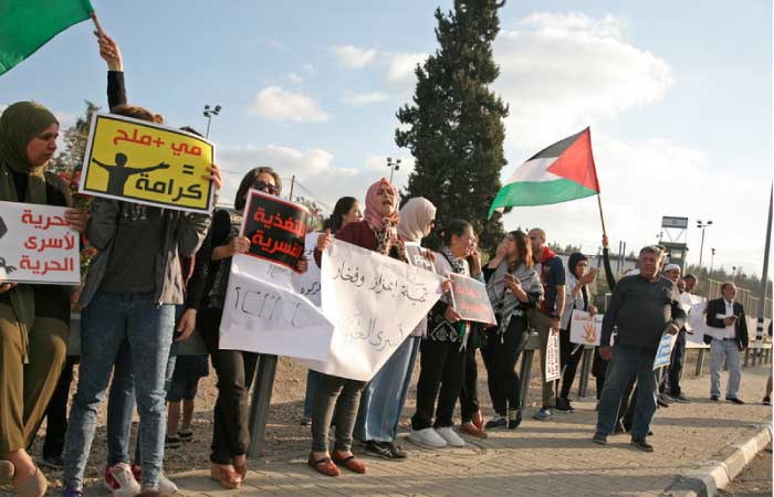Protesters hold placards showing pictures of Palestinian prisoners on hunger strike.