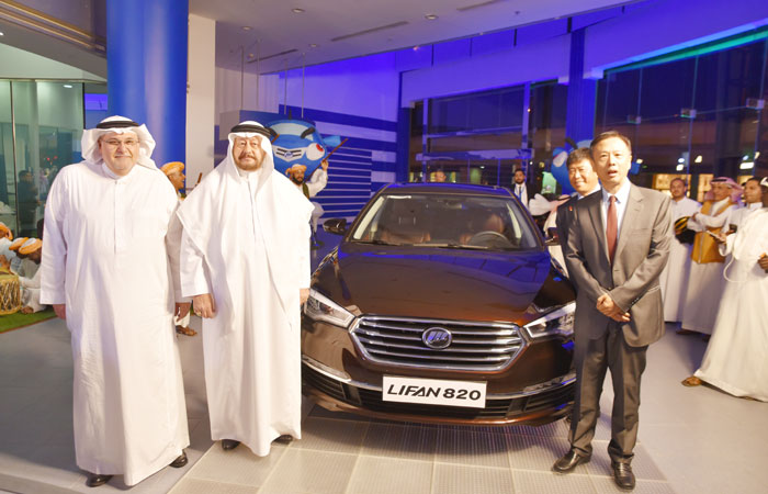 Kamal Halal, Sheikh Mustafa Al Shair, and a delegation from Lifan Motors led by Derek Duan pose beside a Lifan 820 equipped with robust dynamics and cozy maneuverability