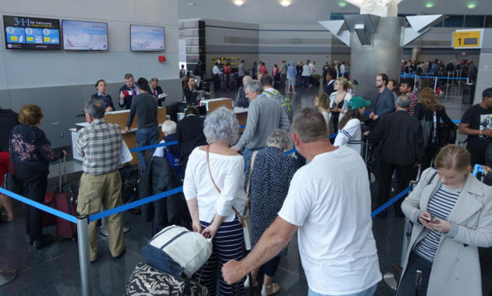 British Airways’ passengers wait in line to re-check into an American Airlines flight in John F. Kennedy (JFK) international airport in New York on Saturday. — AFP