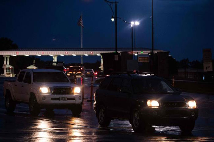 Cars drive out of US Army facility Fort Leavenworth in Leavenworth, Kansas, before dawn, on Wednesday. — AFP