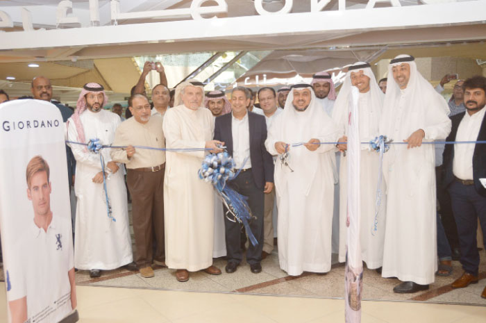 Mazen Baterjee, vice chairman of the Jeddah Chamber of Commerce and Industry, and Ishwar Chugani, managing director of Giordano, cut the ceremonial ribbon, assisted, among others, by Sheikh Hani Abdul Aziz Saab, chairman of the Board, Textile and Garments Co., and Khalid Almaeena, Managing Partner of Quartz Communications. — SG Photo by Abdul Rahman M. Baig