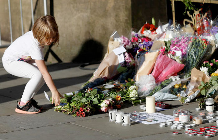 A girl leaves flowers for the victims of an attack on concert goers at Manchester Arena, in central Manchester, Britain May 23, 2017. — Reuters
