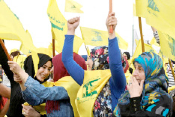 Women wave Hezbollah flags in the Bekaa Valley. — Reuters