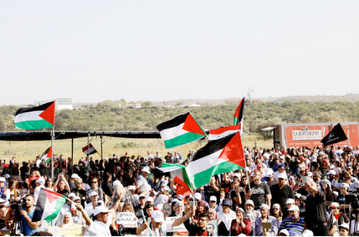 Arab-Israelis men hold Palestinian flags during a protest near Acre in northern Israel to mark the right of return for refugees who fled their homes during the 1948 Israeli attack. — Reuters