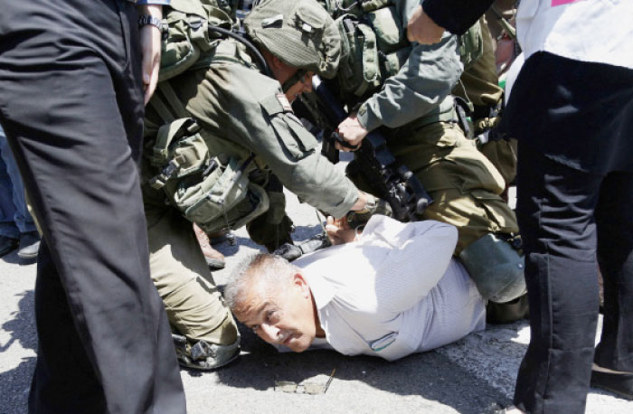 Israeli solders arrest a Palestinian activist during protest in solidarity with Palestinian prisoners on hunger strike in Israeli jails near the settlement of Shavei Shamron near the West Bank city of Nablus, Tuesday. — AP