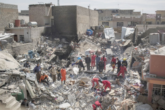 Civil protection rescue teams search through the debris of a house destroyed in a March 17 air strike in the western sector of Mosul in this file photo. — AP