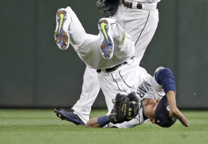 Seattle Mariners center fielder Jarrod Dyson tumbles after snagging a fly ball from Oakland Athletics' Khris Davis in the sixth inning of a baseball game Monday in Seattle. — AP