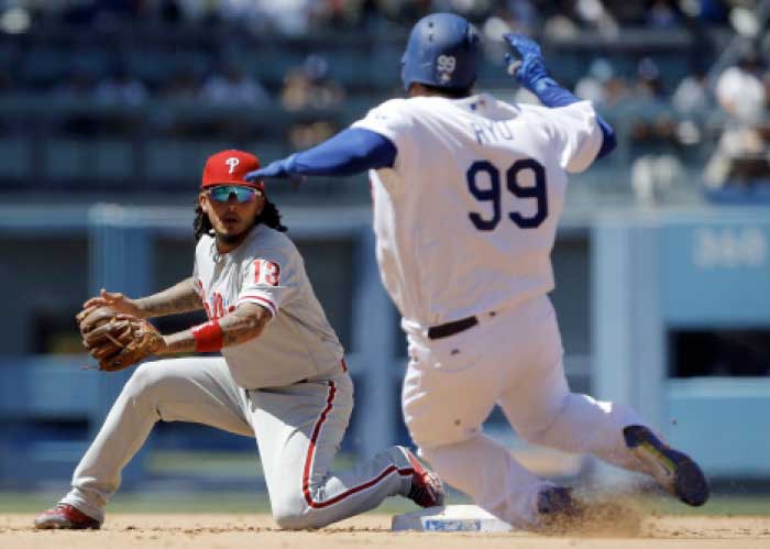 Philadelphia Phillies shortstop Freddy Galvis, left, waits to tag out Los Angeles Dodgers' Hyun-Jin Ryu at second, as Andrew Toles grounds into a double play on a grounder to first during the fourth inning of a baseball game in Los Angeles, Sunday. — AP