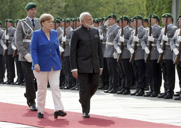 German Chancellor Angela Merkel, left, welcomes Indian Prime Minister Narendra Modi, right, with military honors for a meeting at the chancellery in Berlin, Germany, on Tuesday. — AP