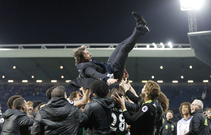 Chelsea manager Antonio Conte is thrown in the air by his players as they celebrate winning the Premier League title Friday. — Reuters