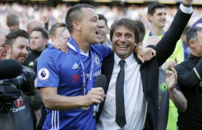 Chelsea captain John Terry celebrates with manager Antonio Conte after they won the English Premier League at Stamford Bridge stadium in London Sunday. — AP