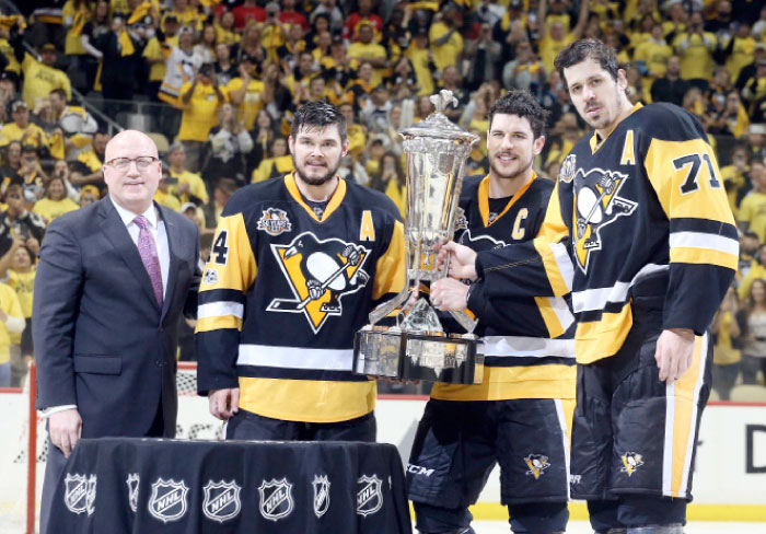 (From L) NHL Deputy Commissioner Bill Daly, Pittsburgh Penguins’ left wing Chris Kunitz, center Sidney Crosby and center Evgeni Malkin pose with the Prince of Wales trophy for the Eastern Conference champion in Pittsburgh Thursday. — Reuters