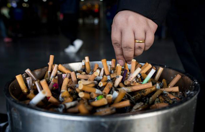 A man grinds out his cigarette in an ashtray at a railway station in Shanghai in this Feb. 28, 2017 file photo. — AFP