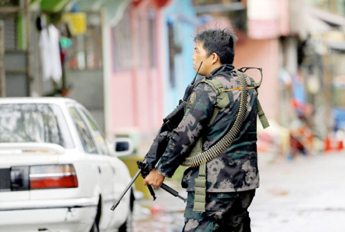 A government soldier takes up position during a patrol along a deserted street in Marawi City, southern Philippines, on Saturday. — Reuters