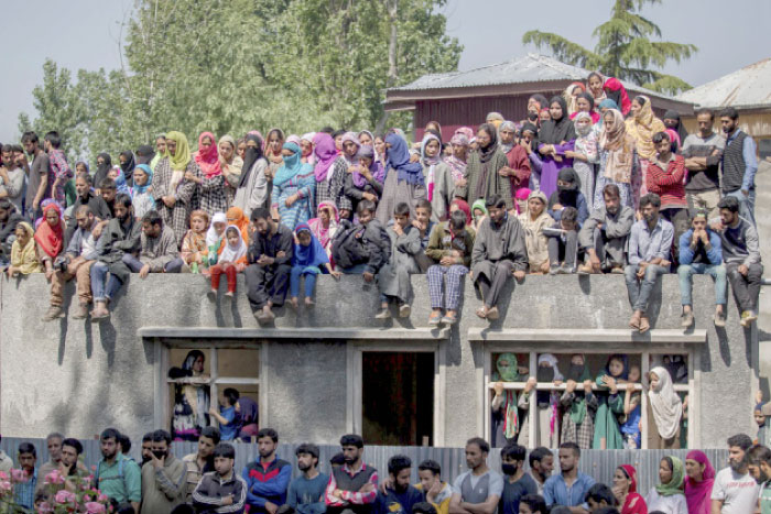 Kashmiri villagers watch the funeral procession of the rebel leader Sabzar Ahmed Bhat in Retsuna 45 km south of Srinagar, Indian controlled Kashmir, on Sunday. — AP