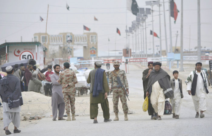 Pakistani paramilitary soldiers stand guard while people wait for the opening of the border crossing in Chaman, Pakistan, in this March 20, 2017 file photo. — AP