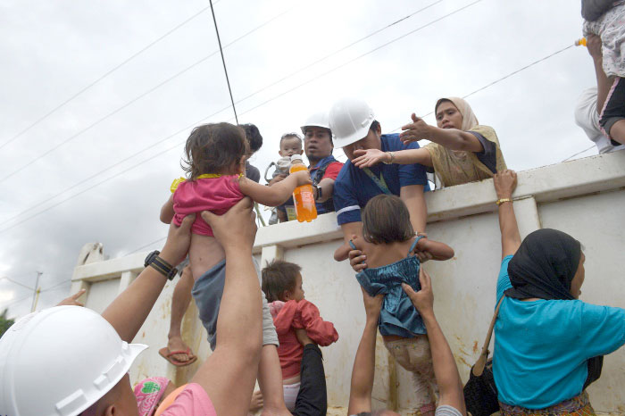 Rescuers help children onto a truck after they were rescued from their homes in a village on the outskirts of Marawi on the southern island of Mindanao on Wednesday, as fighting between government forces and militants continues. — AFP