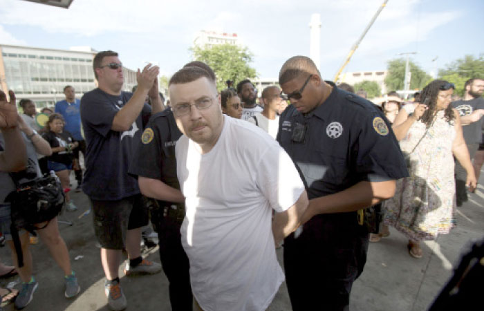 A man is arrested after an altercation with a woman as the statue of Confederate General Robert E. Lee is removed from Lee Circle in New Orleans on Friday. — AP