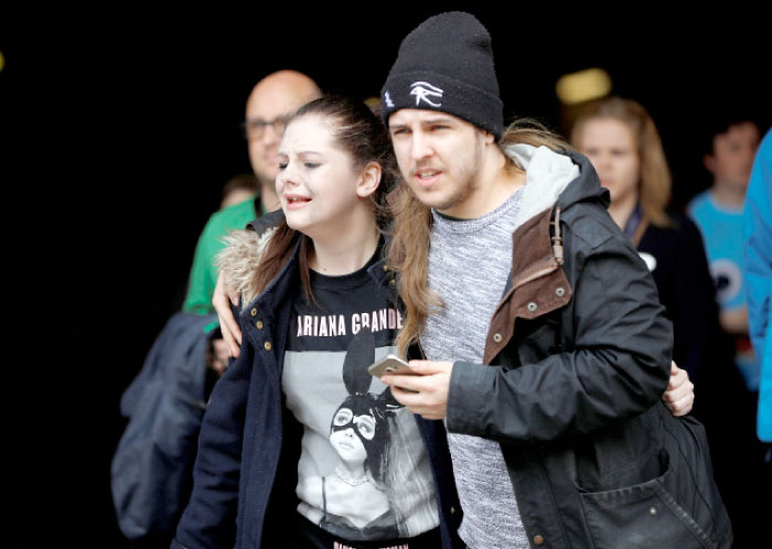 People rush out of the Arndale shopping centre as it is evacuated in Manchester, Britain, on Tuesday. — Reuters