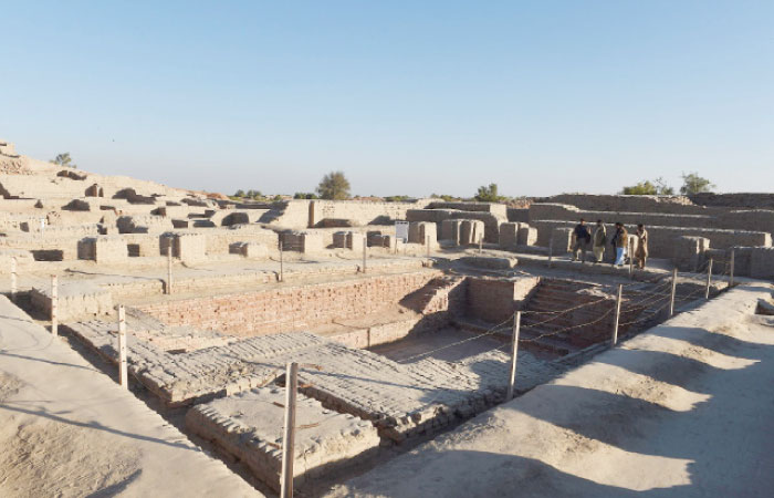 In this photograph taken on Feb. 9, 2017, visitors walk through the UNESCO World Heritage archeological site of Mohenjo Daro, some 425 kilometers north of the Pakistani city of Karachi. — AFP