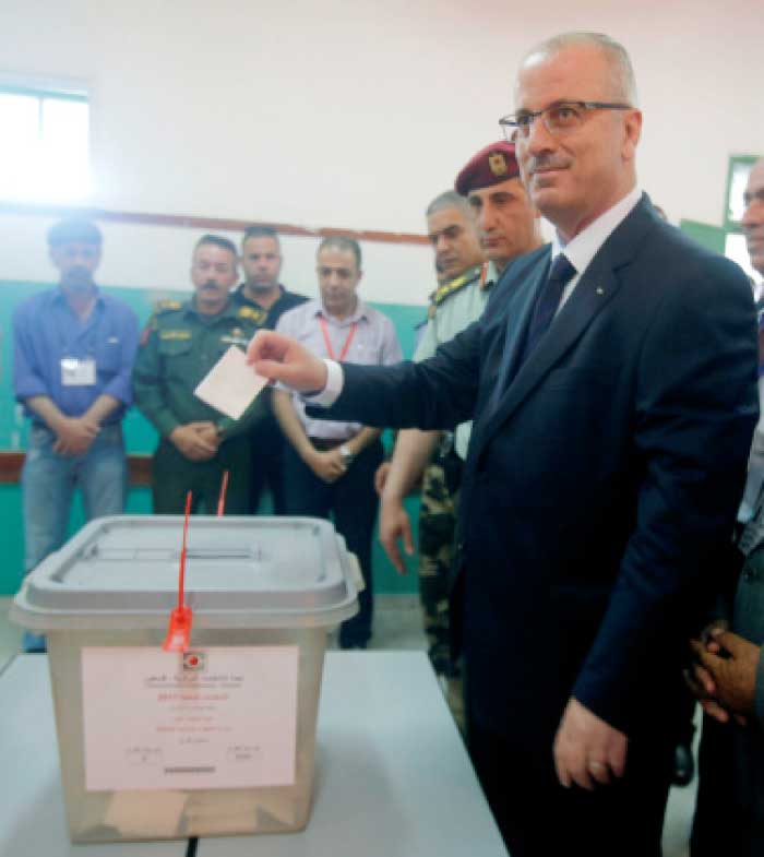 Palestinian Prime Minister Rami Hamdallah casts his ballot at a polling station during municipal elections in the northern West Bank town of Anabta, near Tulkarm, Saturday. — Reuters