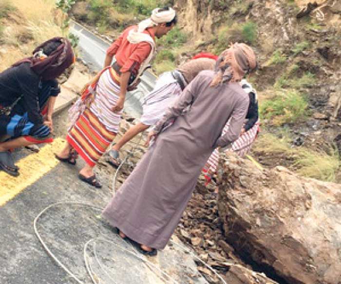 People trying to clear a road of rockslides in Jazan. — Courtesy photo