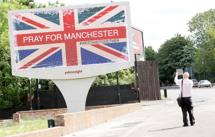 A man photographs a sign in Manchester on Tuesday. — Reuters