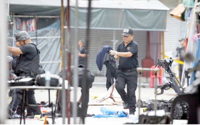 Philippine National Police Bomb Squad remove items at the scene following two overnight explosions in Manila’s Quiapo district, Philippines, on Sunday. — AP