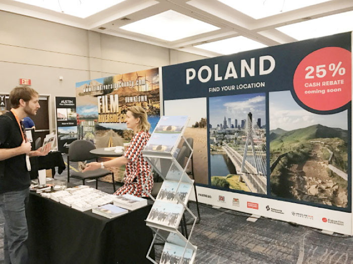 A representative of Poland, one of dozens of officials promoting their production tax incentives at a conference hosted by the Association of Film Commissioners International, speaks with a guest in Burbank, California. — Reuters