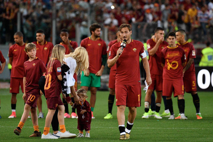 AS Roma's captain Francesco Totti delivers a speech next to his wife Ilary and his children during a ceremony following his last match with AS Roma after the Italian Serie A football match between Roma and Genoa on Sunday. — AFP