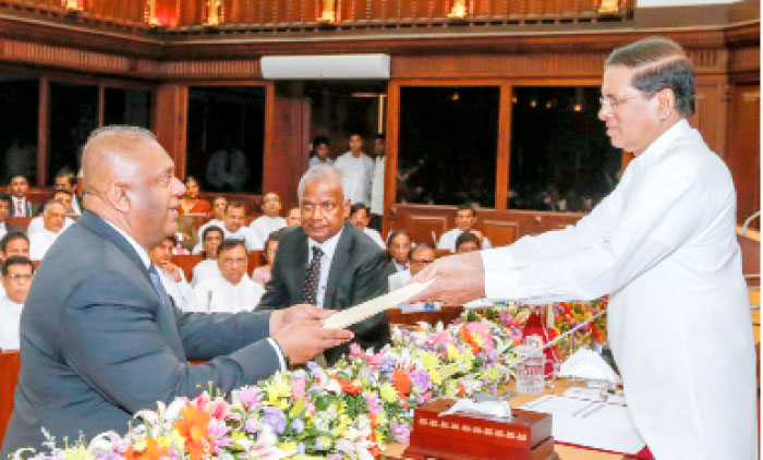 Mangala Samaraweera, left, who has been foreign minister since January 2015 takes an oath as he is sworn in as minister of finance in front of Sri Lanka’s President Maithripala Sirisena in Colombo on Monday. — Reuters