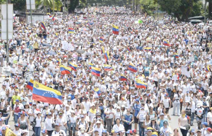 Venezuelan opposition activists take part in a women’s march aimed to keep pressure on President Nicolas Maduro, whose authority is being increasingly challenged by protests and deadly unrest, in Caracas on Saturday. — AFP