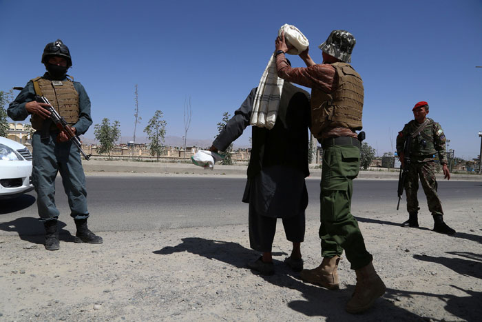 Afghan security soldiers search a man at a checkpoint, ahead of Eid Al-Fitr festivities, at the market in Ghazni province on Saturday. — AFP
