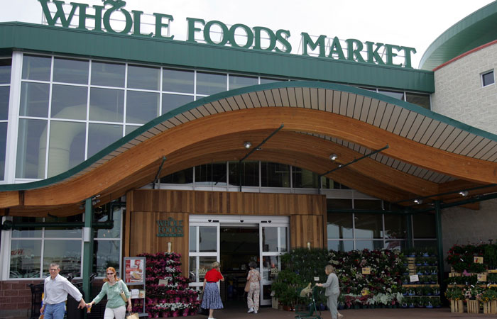 In this file photo, customers are seen outside a Whole Foods Market in Dallas. Online juggernaut Amazon announced Fridaythat it is buying Whole Foods in a deal valued at about $13.7 billion, including debt. — AP