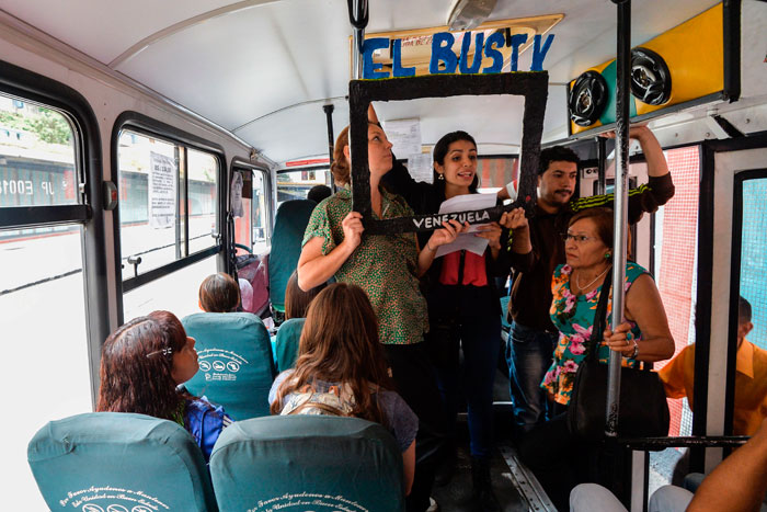 Laura Castillo (L), Maria Gabriela Fernandez (C) and Dereck Blanco (R) give a presentation of the Bus TV news in Caracas, Venezuela. A group of young Venezuelan reporters board buses to present the news, as part of a project to keep people informed in the face of what the opposition and the national journalists' union describe as censorship by the government of Nicolas Maduro. — AFP