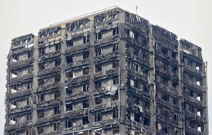 The charred remains of clading are pictured on the outer walls of the burnt out shell of the Grenfell Tower block in north Kensington, west London on June 22, 2017.  — AFP