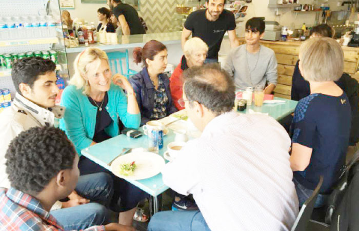 Refugees and potential hosts enjoy a meal at a cafe in Surrey, England organized by Refugees at Home.