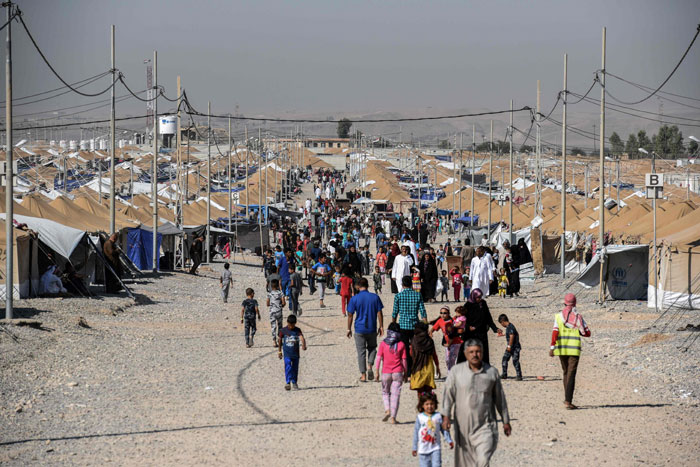 Displaced Iraqis who fled the fighting in Mosul walk at the Salamya camp for internally displaced people, south of the embattled city in the Nimrud area, on Sunday, on the first day of Eid Al-Fitr holidays. — AFP