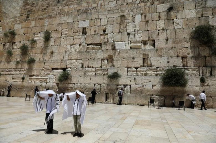 File photo shows youth hold their prayer shawls as they stand in front of the Western Wall in Jerusalem's Old City. — Reuters