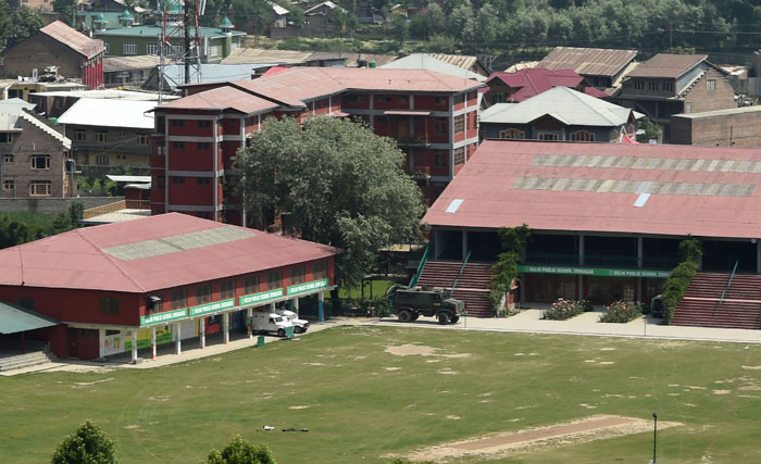 Indian army vehicles are stationed inside the Delhi Public School (DPS) during a gunfight with suspected militants and Indian government forces at Panthachowk on the outskirts of Srinagar on Sunday. — AFP