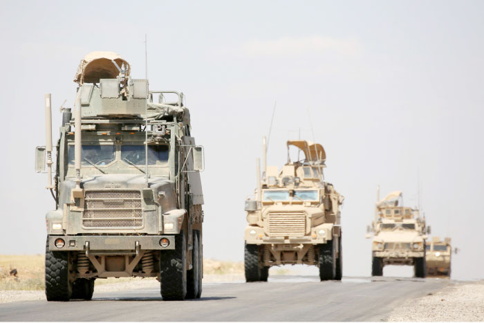 US-made armored vehicles are seen on a road near the northern Syrian village of Ain Issa. — AFP