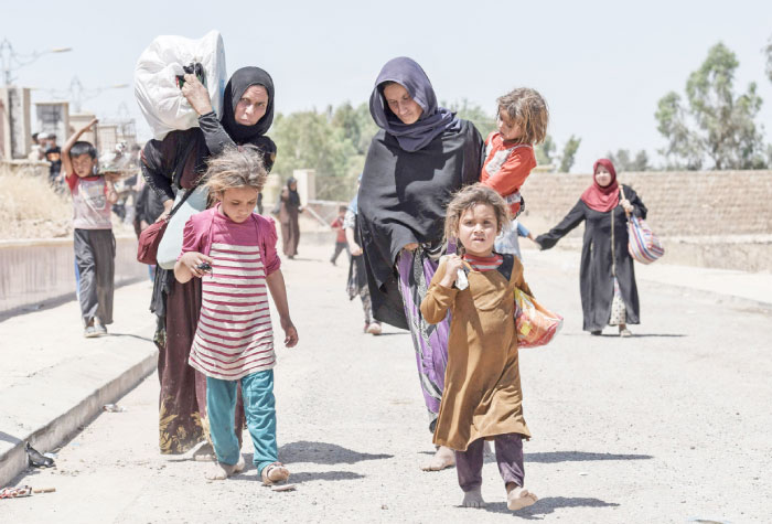 Displaced Iraqis arrive at a temporary camp at the compound of the closed Nineveh International Hotel in Mosul which was recovered by Iraqi troops from Daesh group fighters earlier in the year.  A screening center set up in the compound’s fairgrounds sees a constant stream of Iraqis fleeing the battle for Mosul, awaiting their turn to be checked by the Iraqi forces who are searching for suspected Daesh group members. The small fairground lies at the end of a pontoon bridge across the Tigris recently opened to civilians that is the only physical link between the two banks of the river. — AFP