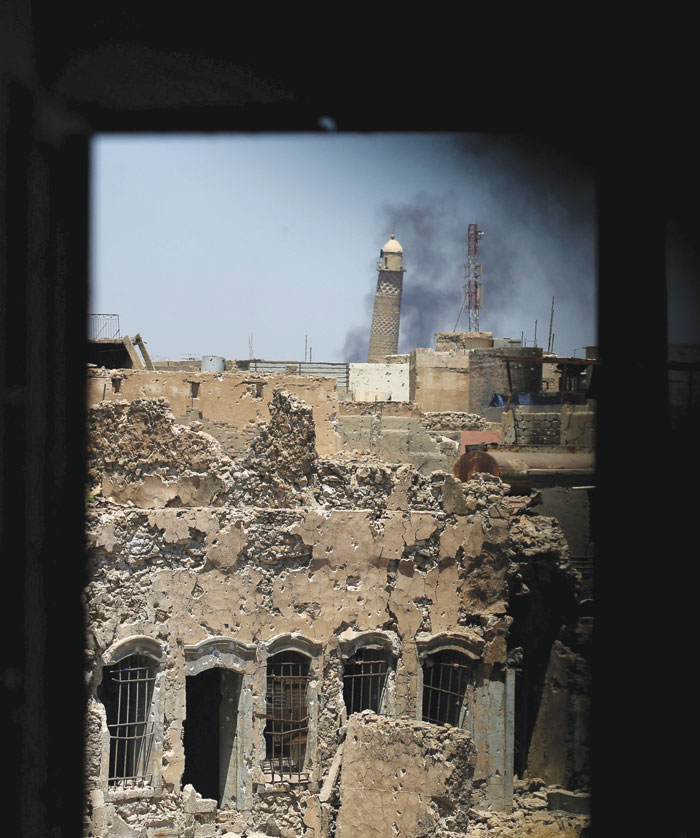 Al-Hadha minaret at Grand Mosque is seen through a building window in the old city of mosul, in the photo taken earlier this month