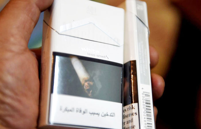 A man displays a pack of cigarettes outside a tobacco shop in Riyadh. — AFP